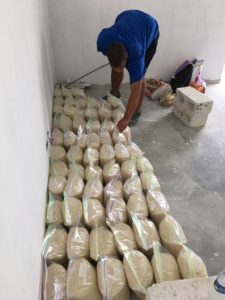 Hector counts the bags of rice to be distributed to families